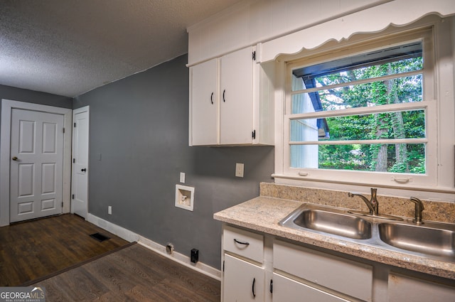 kitchen featuring a textured ceiling, dark hardwood / wood-style floors, white cabinetry, and sink