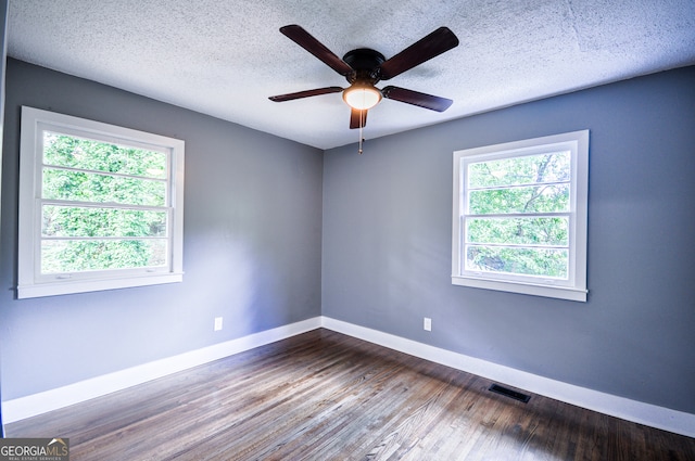 empty room featuring hardwood / wood-style floors, ceiling fan, a healthy amount of sunlight, and a textured ceiling