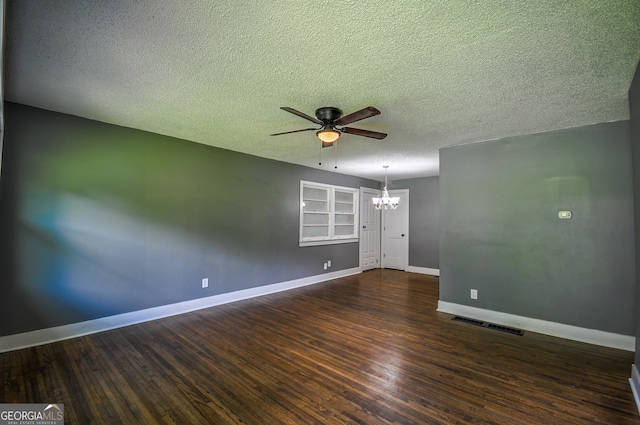 empty room with ceiling fan with notable chandelier, a textured ceiling, and dark hardwood / wood-style floors