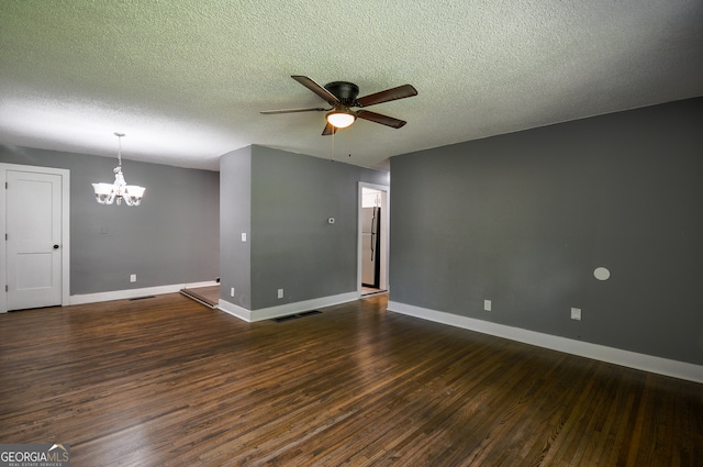 spare room with a textured ceiling, ceiling fan with notable chandelier, and dark hardwood / wood-style floors