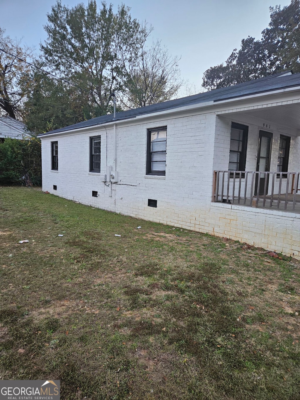 view of property exterior featuring a porch and a lawn