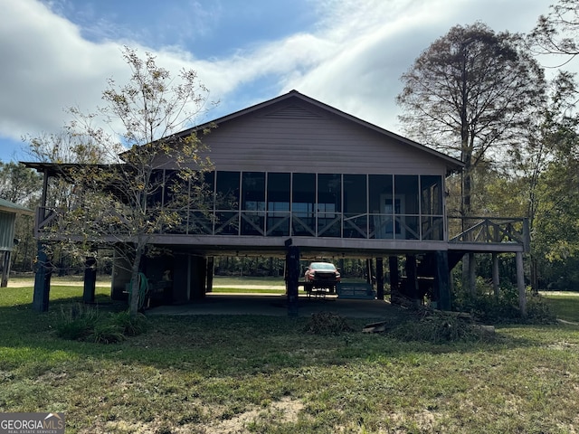 back of property with a yard, a carport, and a sunroom