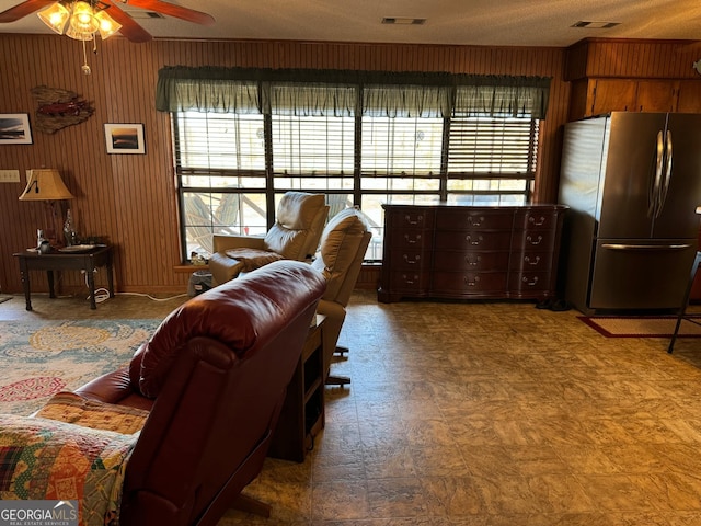 living room with ceiling fan and a textured ceiling