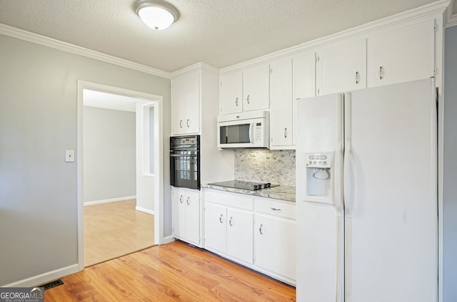 kitchen featuring white cabinetry, light hardwood / wood-style flooring, decorative backsplash, black appliances, and ornamental molding