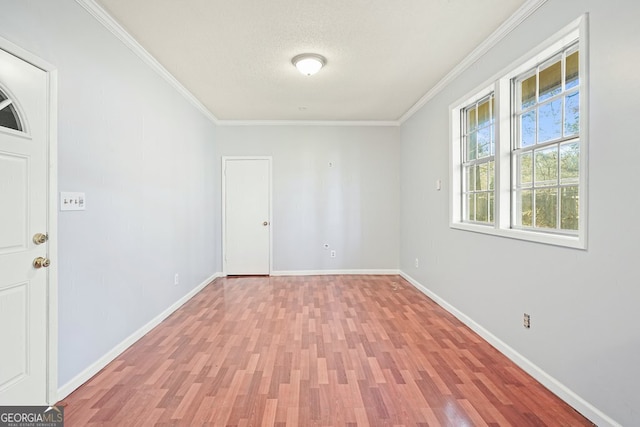 unfurnished room with ornamental molding, a textured ceiling, and light wood-type flooring