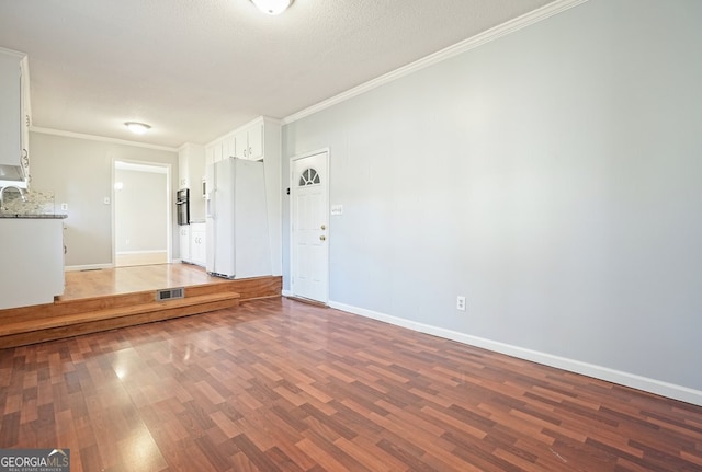 empty room with crown molding, dark wood-type flooring, and a textured ceiling