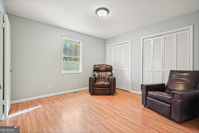 living area featuring a textured ceiling and light wood-type flooring