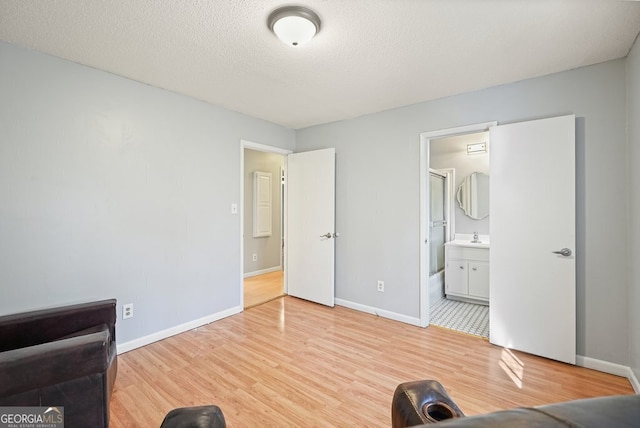 sitting room featuring a textured ceiling and light hardwood / wood-style flooring