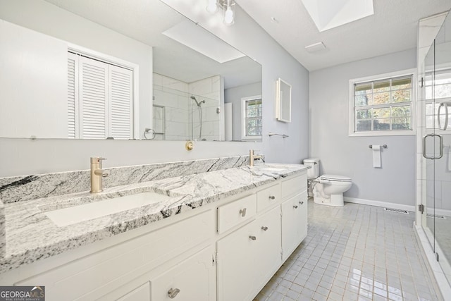 bathroom with a skylight, tile patterned floors, a textured ceiling, a shower with door, and vanity