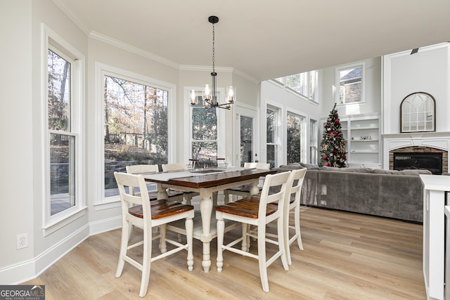 dining area with a wealth of natural light, light hardwood / wood-style flooring, and ornamental molding