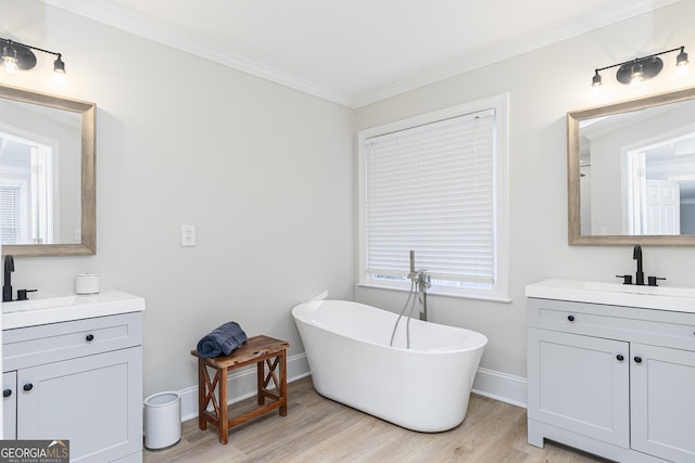 bathroom featuring vanity, hardwood / wood-style floors, a bathtub, and ornamental molding