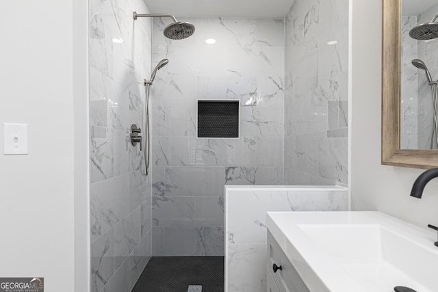 bathroom featuring a tile shower and vanity