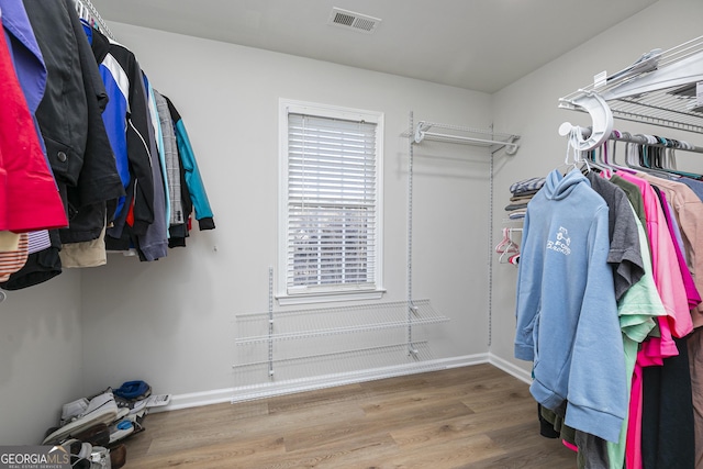 walk in closet with hardwood / wood-style floors