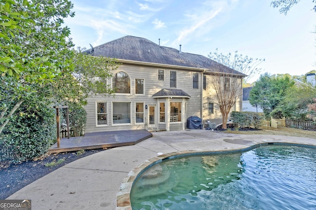 back of house with a pool side deck and a patio