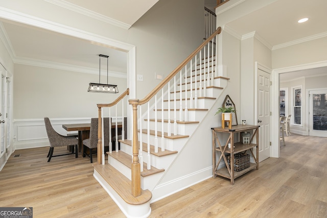 staircase featuring crown molding and hardwood / wood-style floors