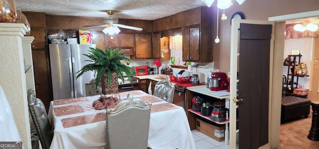 kitchen featuring stainless steel refrigerator, ceiling fan, light carpet, and a textured ceiling