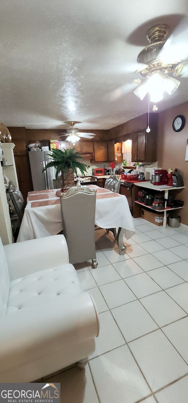 dining room with ceiling fan, light tile patterned floors, and a textured ceiling