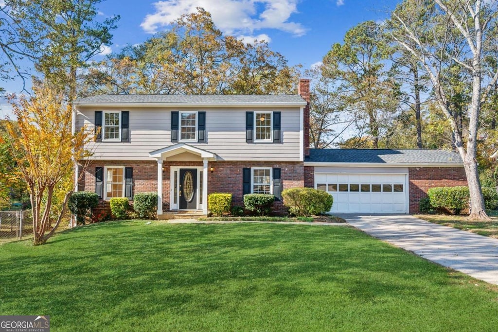 colonial home featuring a front yard and a garage