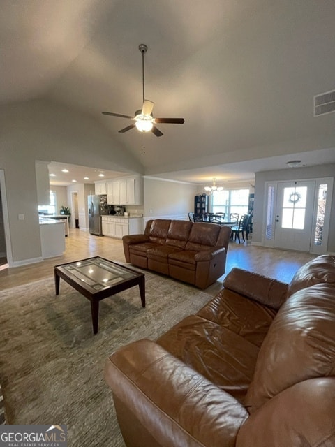 living room with light hardwood / wood-style flooring, vaulted ceiling, and ceiling fan