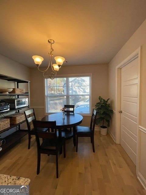 dining space featuring a notable chandelier and light hardwood / wood-style floors