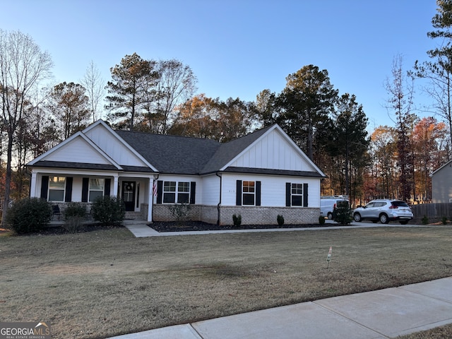 view of front of house featuring covered porch and a front yard