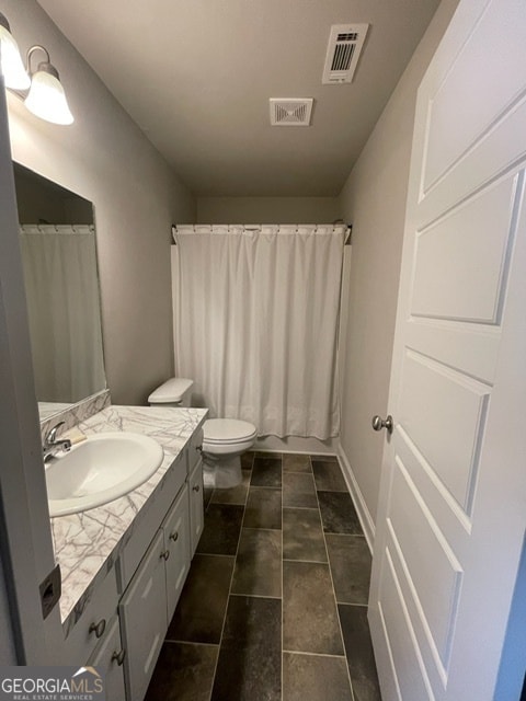 bathroom featuring vanity and toilet