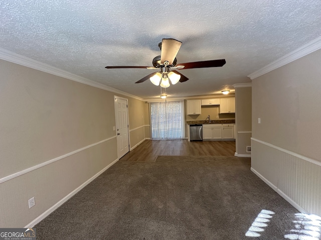 unfurnished living room with ceiling fan, dark carpet, ornamental molding, and a textured ceiling