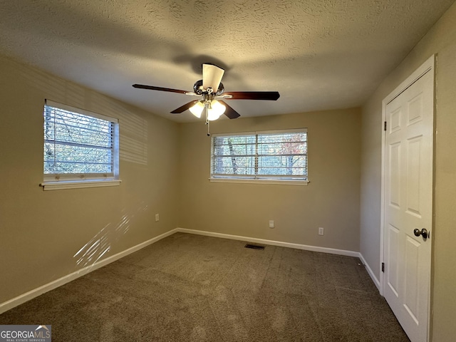 4906 Springbrook Dr, Douglasville, GA 30135 - unfurnished bedroom with a textured ceiling, dark colored carpet, and a ceiling fan