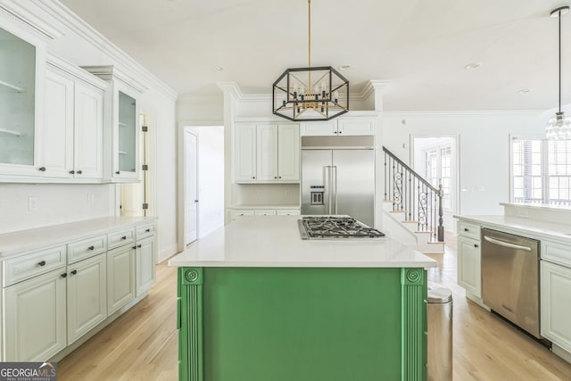 kitchen with decorative light fixtures, stainless steel appliances, and a kitchen island