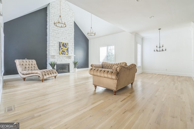 living room featuring ornamental molding, high vaulted ceiling, light hardwood / wood-style floors, and a brick fireplace