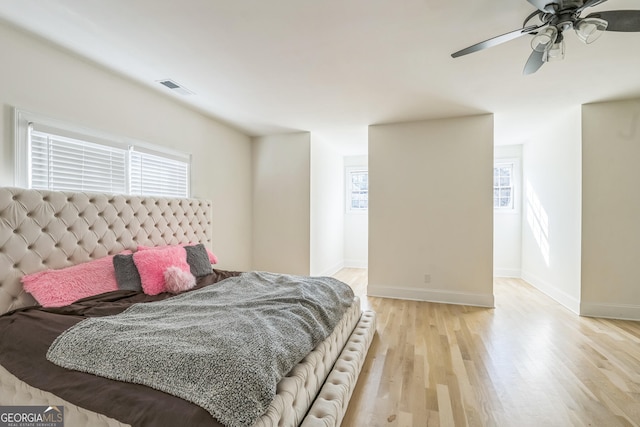 bedroom featuring multiple windows, ceiling fan, and light wood-type flooring