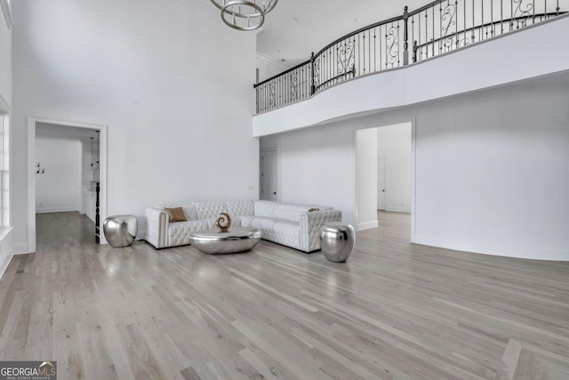 living room featuring light wood-type flooring and a high ceiling