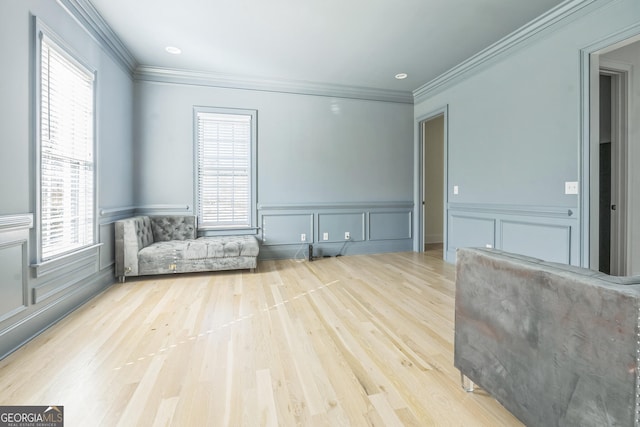 unfurnished room featuring ornamental molding, a healthy amount of sunlight, and light hardwood / wood-style floors