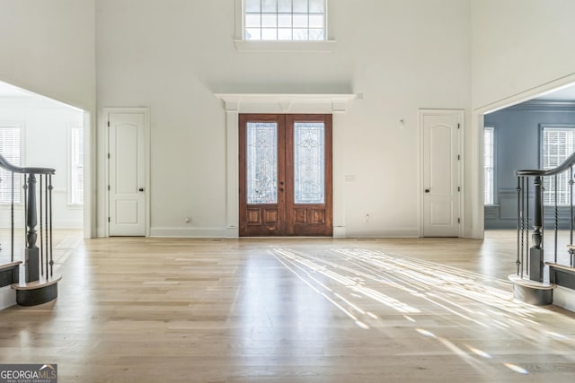 foyer featuring plenty of natural light, a high ceiling, and french doors