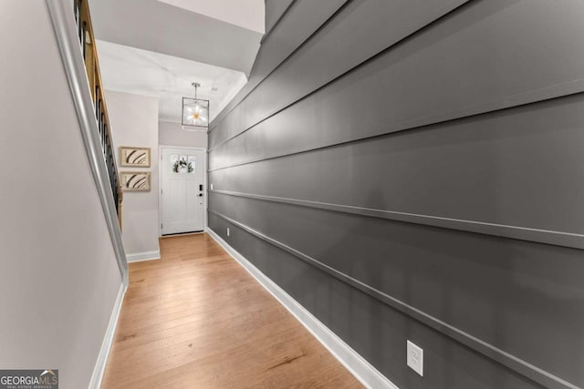 corridor featuring a chandelier and light hardwood / wood-style flooring