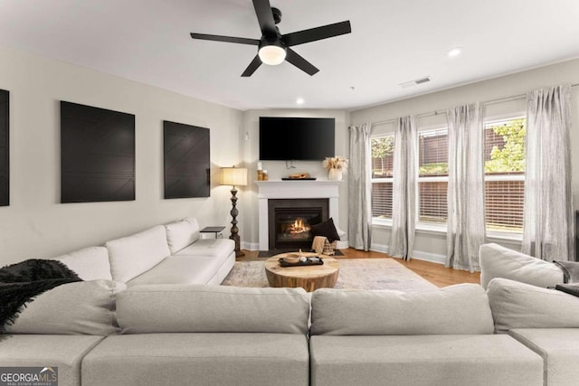 living room featuring ceiling fan and light hardwood / wood-style floors