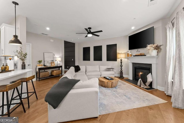 living room featuring ceiling fan and light wood-type flooring