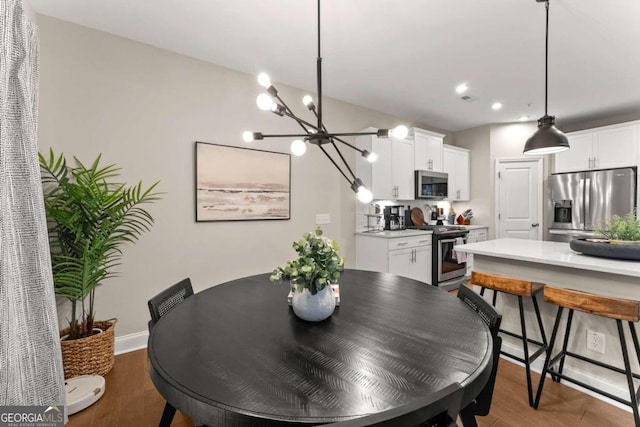 dining space featuring hardwood / wood-style flooring and a notable chandelier