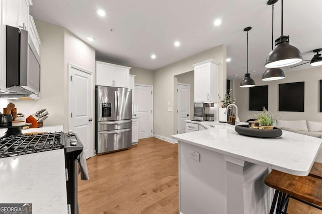 kitchen with pendant lighting, sink, white cabinetry, and stainless steel refrigerator with ice dispenser