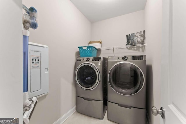 laundry room featuring light tile patterned floors and washing machine and clothes dryer