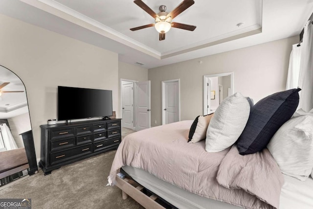 bedroom with carpet, ceiling fan, and a tray ceiling