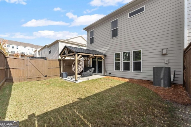 back of property featuring a gazebo, cooling unit, a patio area, and a lawn