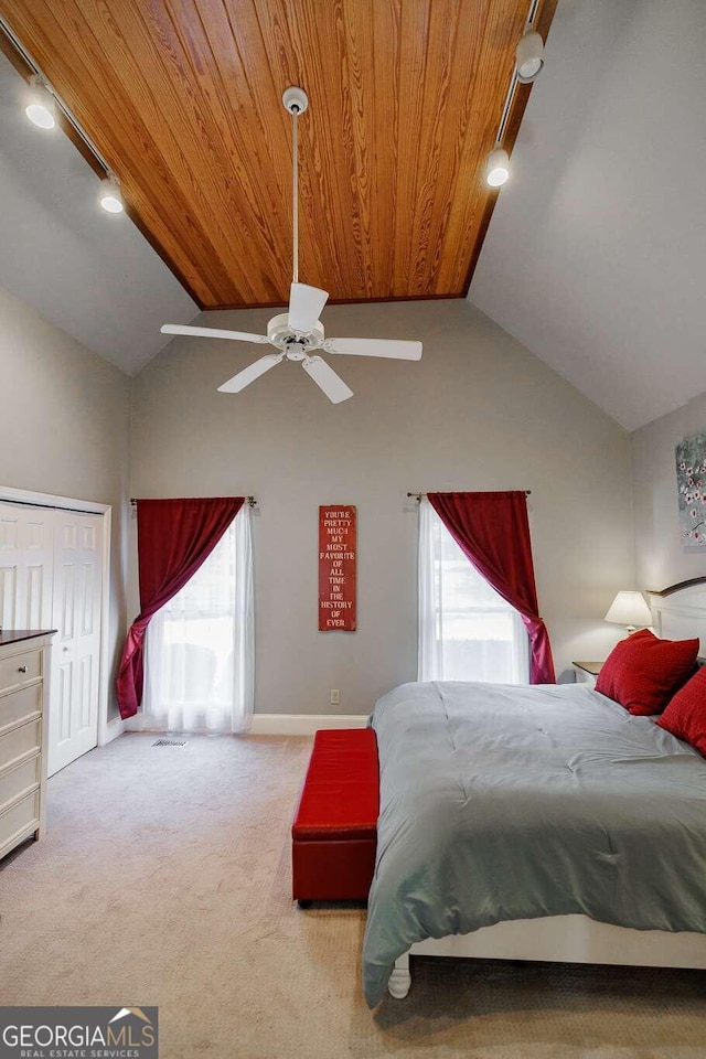 carpeted bedroom with rail lighting, vaulted ceiling, and ceiling fan