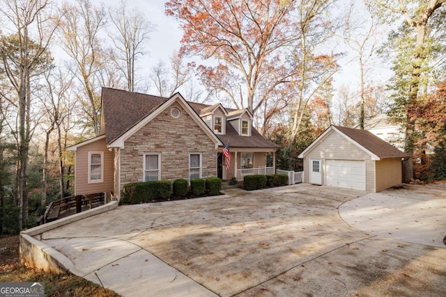 view of front of property featuring a garage, covered porch, and an outbuilding