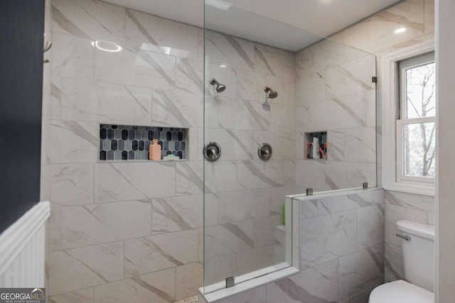 bathroom featuring a tile shower and toilet