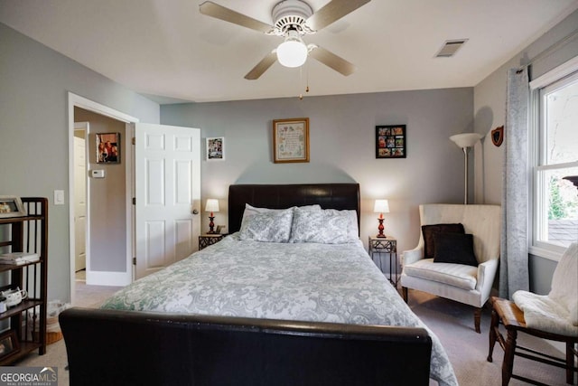 carpeted bedroom with multiple windows and ceiling fan