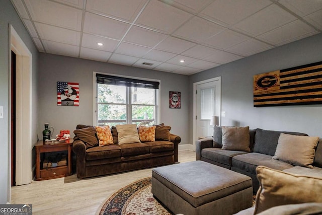 living room featuring a drop ceiling and wood-type flooring