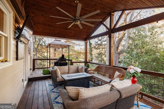 sunroom with ceiling fan, wooden ceiling, and vaulted ceiling