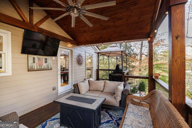 sunroom featuring lofted ceiling with beams, ceiling fan, and wood ceiling