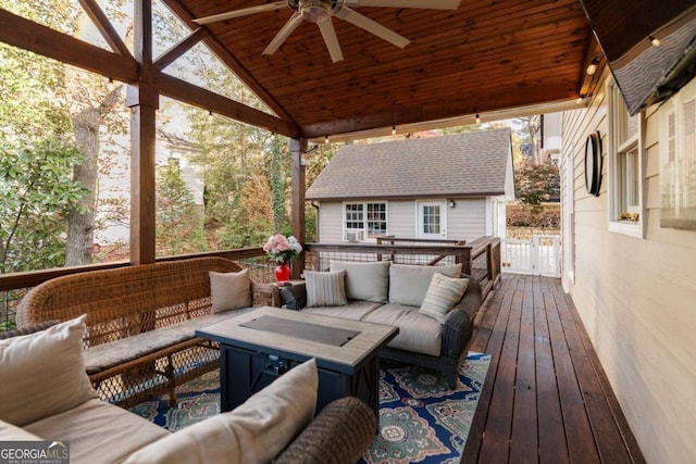 wooden terrace with an outdoor living space, ceiling fan, and an outdoor structure